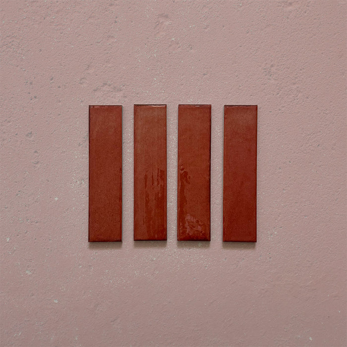 Product image of Play Coral Rectified Brick 5x20cm wall and floor tiles, featuring a glossy coral finish with rich tonal variation and clean rectified edges, displayed to highlight the tile's contemporary handcrafted appearance.