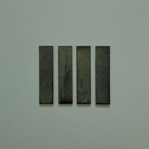 Product image of Play Forest Green Rectified Brick 5x20cm wall and floor tiles, featuring a glossy deep green finish with rich tonal variation and clean rectified edges, displayed to highlight the tile's contemporary handcrafted appearance.