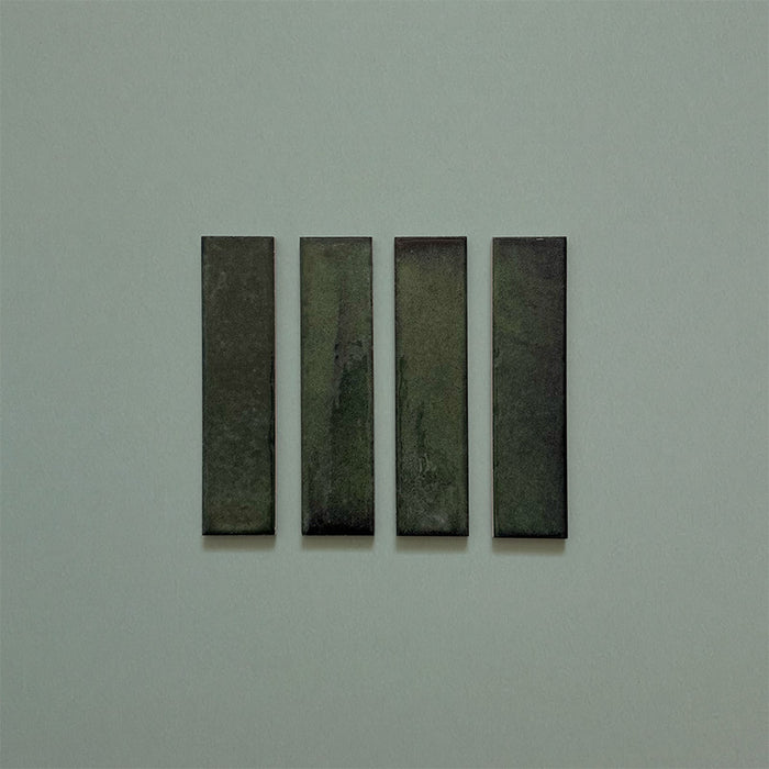 Product image of Play Forest Green Rectified Brick 5x20cm wall and floor tiles, featuring a glossy deep green finish with rich tonal variation and clean rectified edges, displayed to highlight the tile's contemporary handcrafted appearance.
