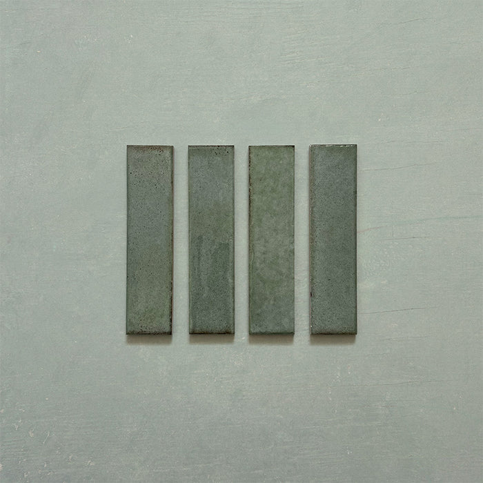 Product image of Play Sage Green Rectified Brick 5x20cm wall and floor tiles, featuring a glossy sage green finish with subtle tonal variation and clean rectified edges, displayed to highlight the tile's contemporary handcrafted appearance.