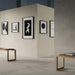 Contemporary gallery-style interior featuring Riminy Light concrete-style wall and floor tiles 60 × 60cm, showcasing soft light grey concrete-effect tones with subtle texture, paired with minimalist furnishings and modern monochrome artwork.
