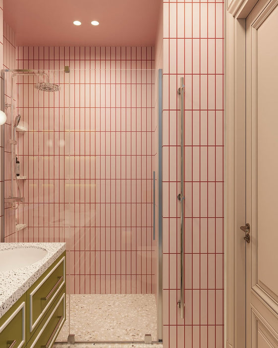 Bathroom interior featuring Rippled Brick Base Stony Pink 5 × 20cm matt ceramic wall tiles, laid vertically with fine linear detail, paired with a glass shower enclosure, terrazzo-effect flooring, and a playful, colour-led vanity area.