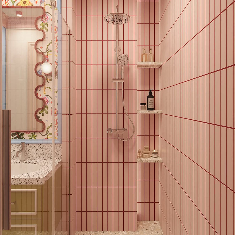 Bathroom interior featuring Rippled Brick Base Stony Pink 5 × 20cm matt ceramic wall tiles, laid vertically with fine linear detail, paired with a glass shower enclosure, terrazzo-effect flooring, and a playful, colour-led vanity area.