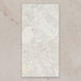 Single tile view of Contract Pebble Rock Blanca 60x120cm terrazzo effect porcelain tile, showcasing soft white and beige tones with varied stone fragments and a natural, blended surface pattern.