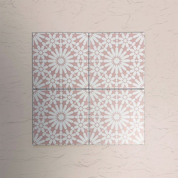 Arrangement of Fizaan Pink Rose 20x20cm Moroccan-style porcelain tiles, showcasing a repeating geometric pattern in soft pink and white tones.
