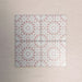 Arrangement of Fizaan Pink Rose 20x20cm Moroccan-style porcelain tiles, showcasing a repeating geometric pattern in soft pink and white tones.