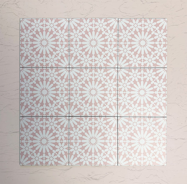 Arrangement of Fizaan Pink Rose 20x20cm Moroccan-style porcelain tiles, showcasing a repeating geometric pattern in soft pink and white tones.