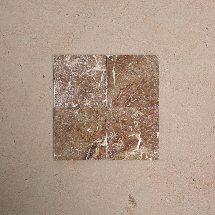 Fitzrovia Rosso 15.2x15.2cm tumbled natural marble tiles arranged in a square layout, showcasing warm terracotta tones, varied veining, tonal variation, and a softly aged, textured finish.