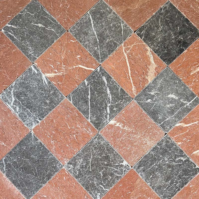 Flat lay of Fitzrovia Rosso 15.2x15.2cm tumbled natural marble tiles paired with dark marble in a classic chequerboard pattern, showcasing rich terracotta tones, deep charcoal contrast, natural veining, and an aged textured finish.