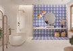 Bathroom featuring Santillana Blue and Yellow patterned wall and floor tiles, showcasing a bold Mediterranean-inspired floral geometric design in vibrant cobalt blue, warm yellow and crisp white tones, paired with a floating stone vanity, round mirror, woven pendant lights, natural baskets and soft neutral finishes for a bright, characterful interior.