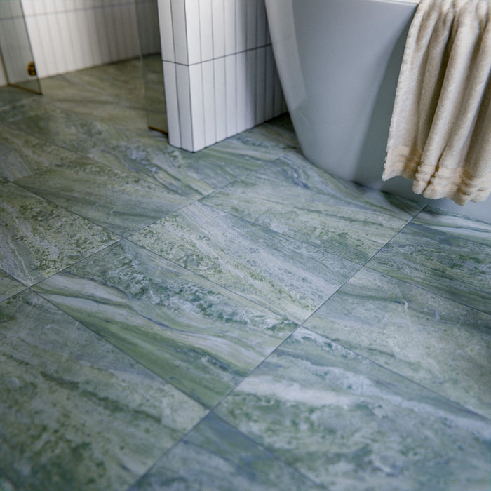 Bathroom featuring Paradis Marble Verde Green marble-style porcelain wall tiles in a 30 × 60cm format, creating a calming spa-like backdrop behind a freestanding bath.