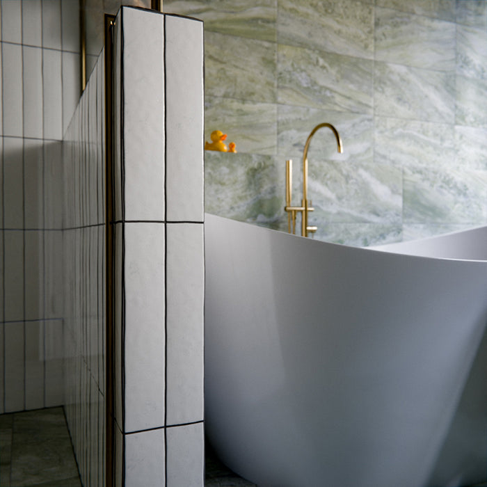 Bathroom featuring Malaga White Sand Brick gloss ceramic wall tiles in a 6.5 × 32.8cm format, laid vertically around the shower and bath for a clean, contemporary finish.