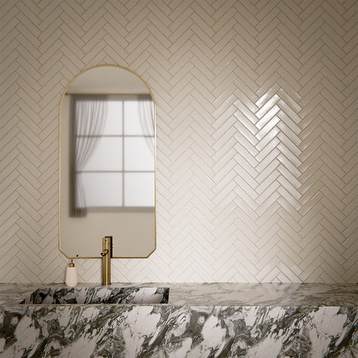 Bathroom interior featuring Play White Brick rectified wall and floor tiles in 5x20cm format, installed in a classic herringbone pattern, styled with a marble vanity and brushed brass fittings for a clean, contemporary finish.
