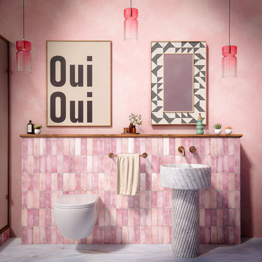 Bathroom setting featuring Fusion Bricks Coral Pink 6.5x20cm brick wall tiles, showcasing soft tonal variation, paired with a fluted marble basin, brass fittings and warm pink walls for a refined, design-led finish.