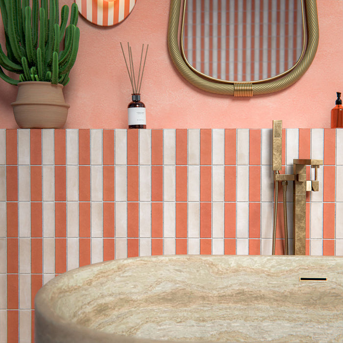 Bathroom setting featuring Atlas Canvas and Atlas Cotto Mini Brick 5x15cm matt wall and floor tiles, laid in a striped layout, showcasing warm neutral and terracotta tones, paired with a freestanding stone bath and brass fittings.