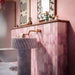 Bathroom setting featuring Fusion Bricks Coral Pink 6.5x20cm brick wall tiles, showcasing soft tonal variation, paired with a fluted marble basin, brass fittings and warm pink walls for a refined, design-led finish.