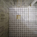 Shower floor featuring Agraba Natural 20×20cm Moroccan-style patterned tiles in soft neutral tones, laid to create a subtle geometric pattern that adds warmth, texture and visual interest to the bathroom.
