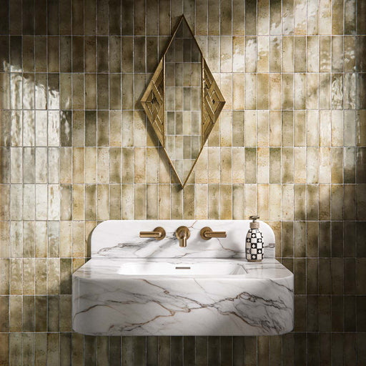 Bathroom interior featuring Fusion Bricks Moss Green 6.5x20cm ceramic wall tiles, arranged in a stacked layout with tonal variation, styled with a marble-effect basin, brass fittings, and a geometric mirror.