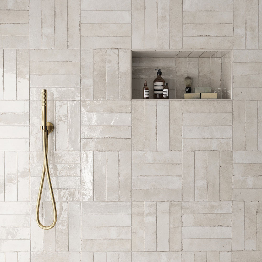 Madison Oatmeal Brick Wall Tiles 6x24.6cm — shown in a serene shower setting. These warm neutral tiles blend soft beige and cream tones with a handcrafted texture and glossy finish, creating a spa-like atmosphere that feels both timeless and contemporary.