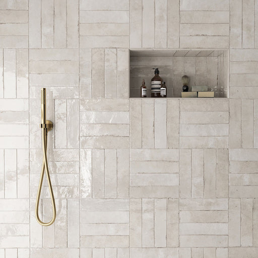 Madison Oatmeal Brick Wall Tiles 6x24.6cm — shown in a serene shower setting. These warm neutral tiles blend soft beige and cream tones with a handcrafted texture and glossy finish, creating a spa-like atmosphere that feels both timeless and contemporary.