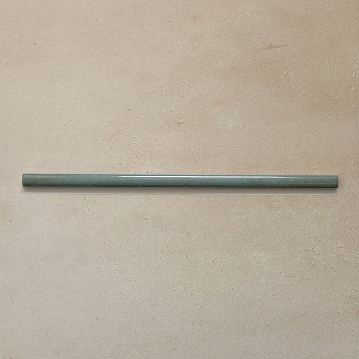 Izmir Celadon Green Gloss Pencil Bullnose Border Tile 1.2x30cm displayed on a neutral beige background, showing its slim curved edge and smooth glazed finish.