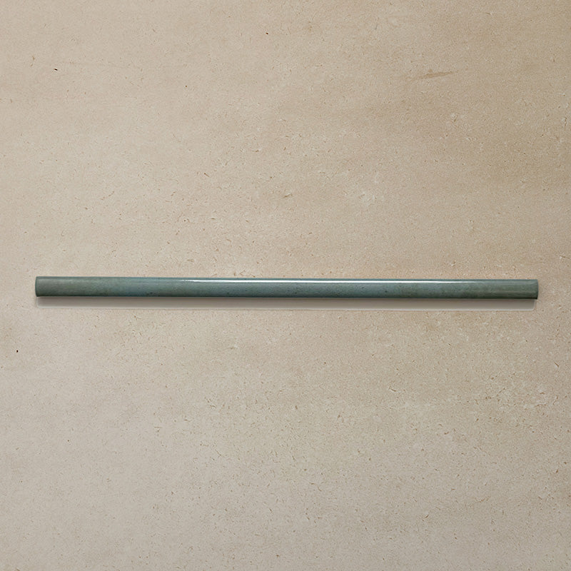 Izmir Celadon Green Gloss Pencil Bullnose Border Tile 1.2x30cm displayed on a neutral beige background, showing its slim curved edge and smooth glazed finish.