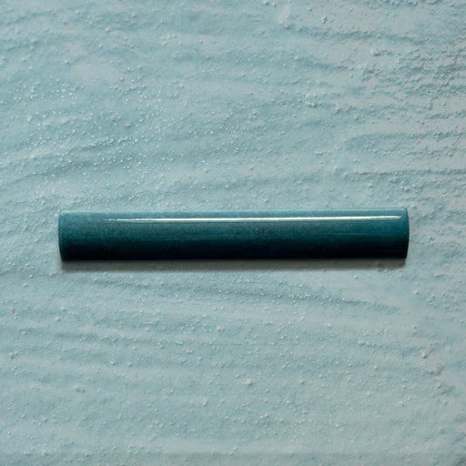 Zellij Peacock Green bullnose tile, 3cm x 20cm, Moroccan style glazed ceramic trim in deep peacock green tones with subtle tonal variation, glossy finish, smooth rounded profile, and handcrafted-inspired surface texture, on a pale textured background.