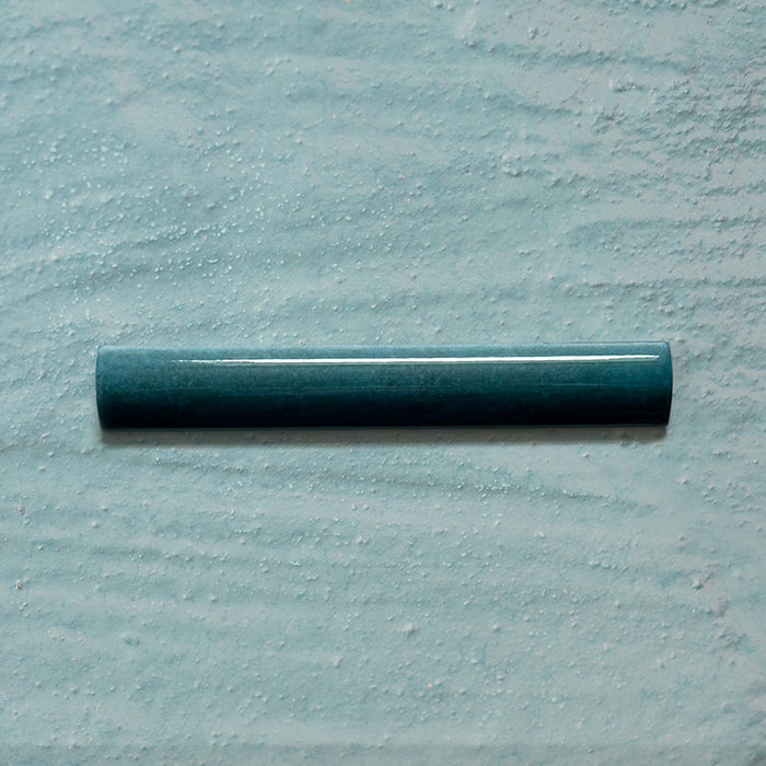 Zellij Peacock Green bullnose tile, 3cm x 20cm, Moroccan style glazed ceramic trim in deep peacock green tones with subtle tonal variation, glossy finish, smooth rounded profile, and handcrafted-inspired surface texture, on a pale textured background.