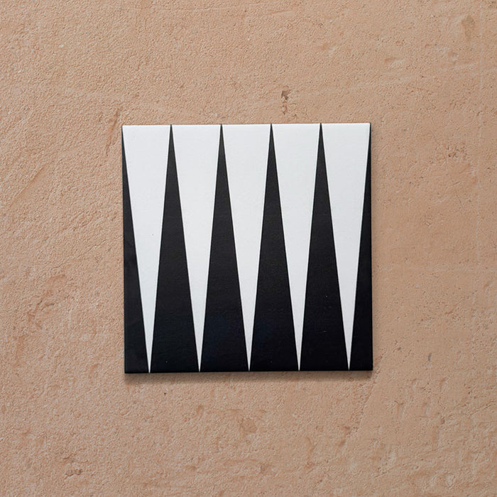 Single Alhambra Tavla 20x20cm Moroccan tile featuring a bold black and white triangular geometric design on a matte surface, displayed against a neutral textured background.
