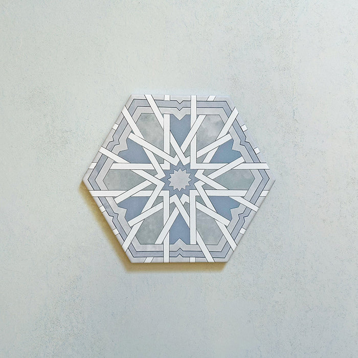 Maroush Mareshan Azure Blue 18.7x21.6cm Moroccan hexagonal tile featuring an intricate white starburst pattern on a soft blue background, inspired by traditional Moroccan craftsmanship.