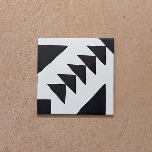 Alhambra Alkazar 20x20cm Moroccan tile shown as a single piece, featuring a bold black and white triangular geometric pattern on a matt surface — ideal for statement floors and contemporary interiors.