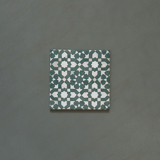 Bedouin Tetuan Green Moroccan-style 15x15cm single tile featuring an intricate star and cross pattern in deep green, soft beige, and white tones, with a subtle handmade effect and matte finish.