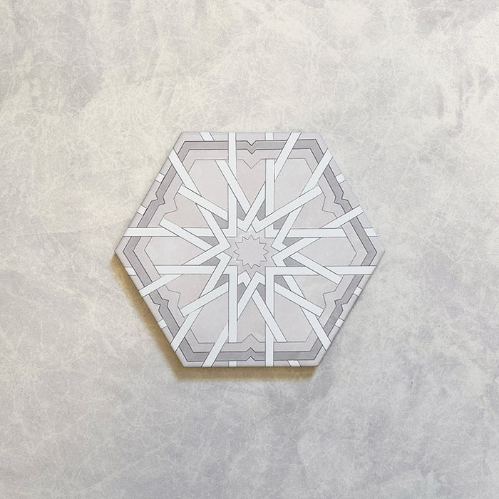Maroush Mareshan Ice White 18.7x21.6cm Moroccan hexagonal tile featuring a detailed geometric star motif in soft white and grey tones on a lightly textured pale surface.