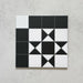 Single Sloane Square 25x25cm Victorian-style ceramic tile featuring a classic black and white geometric star pattern, shown against a light grey textured background in a close-up view.