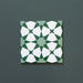 Close-up of Agraba Green 20x20cm Moroccan-style ceramic tile featuring a geometric star pattern in deep and soft green tones with crisp white accents on a dark green background.