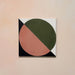 Single tile image showing the Geometry Moon 20x20cm geometric patterned tile with green and terracotta semicircles and black and cream corner details, photographed against a soft peach-toned background.
