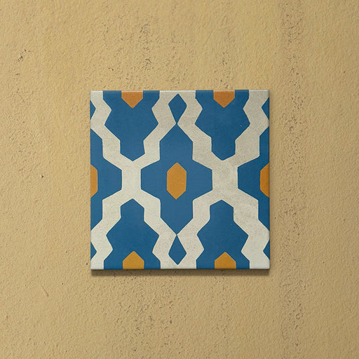 Cabana Zafini Mustard Azure 20x20cm Moroccan-style single porcelain tile with a geometric lattice pattern in deep azure blue and mustard yellow on a soft cream background with a matt finish.