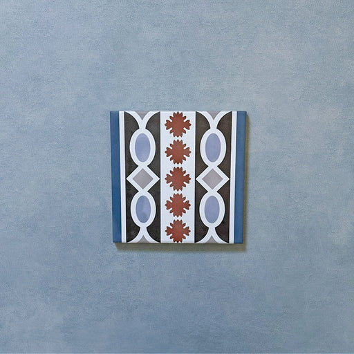Empire Blue 15x15cm Victorian border tile single piece, showcasing a classic interlocking oval and leaf motif in blue, terracotta, white, and charcoal tones for use with matching patterned floor tiles.