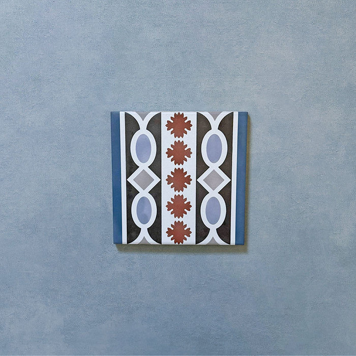 Empire Blue 15x15cm Victorian border tile single piece, showcasing a classic interlocking oval and leaf motif in blue, terracotta, white, and charcoal tones for use with matching patterned floor tiles.