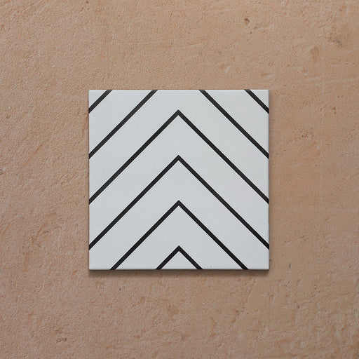Alhambra Zig Zag Blanco 20x20cm Moroccan tile featuring a bold black chevron pattern on a white background, showcasing its modern geometric design and smooth matte finish.