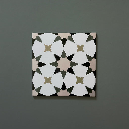 Single Agraba Natural 20x20cm Moroccan tile featuring a geometric star pattern in soft beige, olive, and taupe tones on a matte surface, displayed on a muted green background.