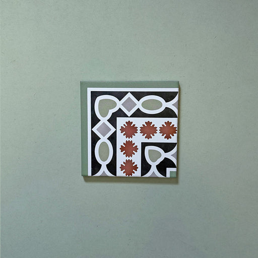 Empire Green 15x15cm Victorian corner tile featuring a classic interlocking pattern in sage green, terracotta, and white, designed to pair seamlessly with matching border tiles for a traditional floor layout.