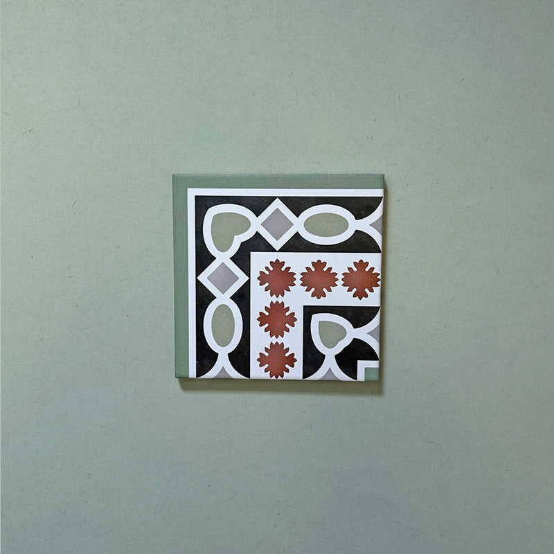 Empire Green 15x15cm Victorian corner tile featuring a classic interlocking pattern in sage green, terracotta, and white, designed to pair seamlessly with matching border tiles for a traditional floor layout.
