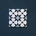 Close-up of Agraba Azul Blue 20x20cm Moroccan-style ceramic tile featuring a geometric star pattern in navy, light blue, and white tones on a deep blue background.