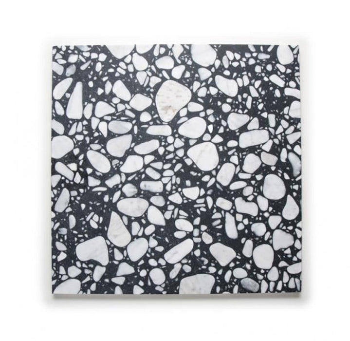 Single Noventa Terrazzo Nero 59x59cm matt porcelain wall and floor tile displayed against a neutral background, showcasing a bold terrazzo effect with contrasting white stone fragments set within a deep black base, highlighting variation in scale and organic detailing across the surface.