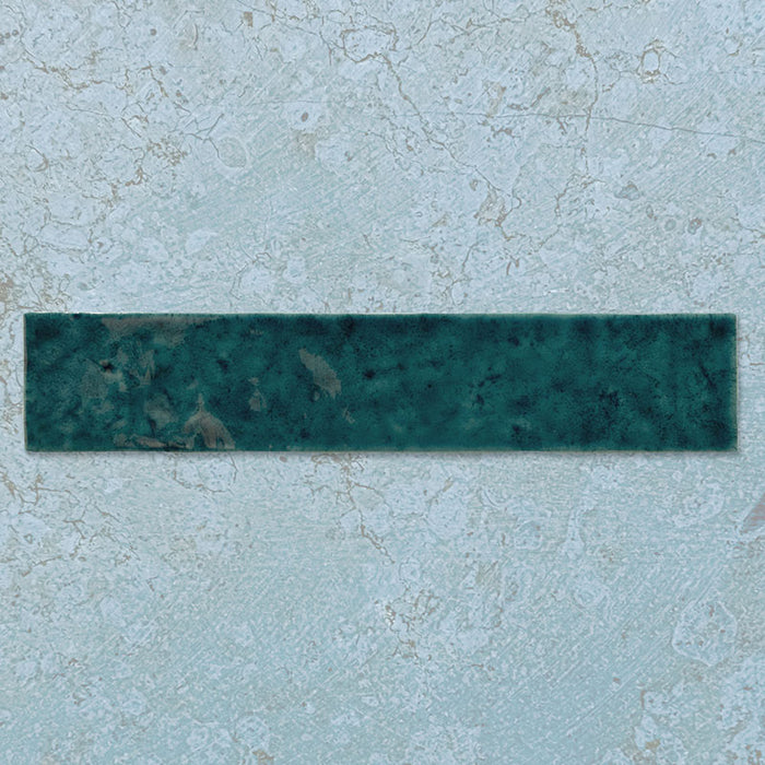 Single Malaga Amun Blue Brick gloss wall tile in 6.5x32.8cm format, featuring deep blue and teal tonal variation with a glossy finish, shown individually against a light textured background to highlight surface detail.