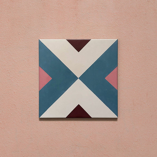 Cabana Guazzatto 20x20cm Moroccan-style porcelain tile featuring a bold geometric cross design in blue, cream, pink, and burgundy shades with a smooth matt finish.