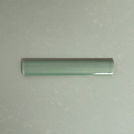 Finchley Lime Green ceramic pencil trim tile in a 2.5 × 15cm format, featuring a crackle glaze finish that adds subtle texture and a refined decorative edge to wall tile designs.