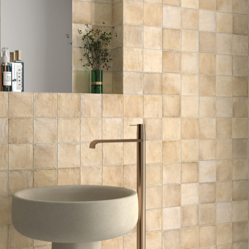 Zellij Arena Square Moroccan Style 10cm x 10cm sink setting, square Moroccan tiles in warm sandy beige and soft cream tones, subtle tonal variation with a lightly textured glazed finish, laid in a neat grid pattern behind a modern basin, creating a warm, handcrafted look ideal for bathroom walls.