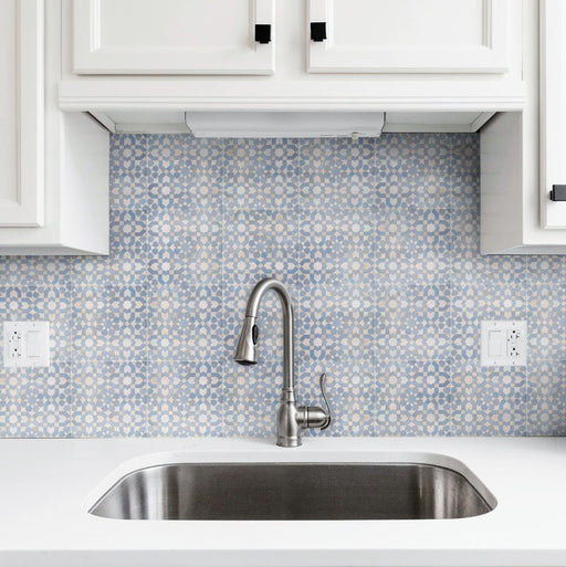 Bedouin Tetuan Blue Moroccan-style 15x15cm tiles used as a kitchen splashback, featuring a soft blue and cream geometric star pattern with white cabinetry, chrome tap, and a clean modern sink area.